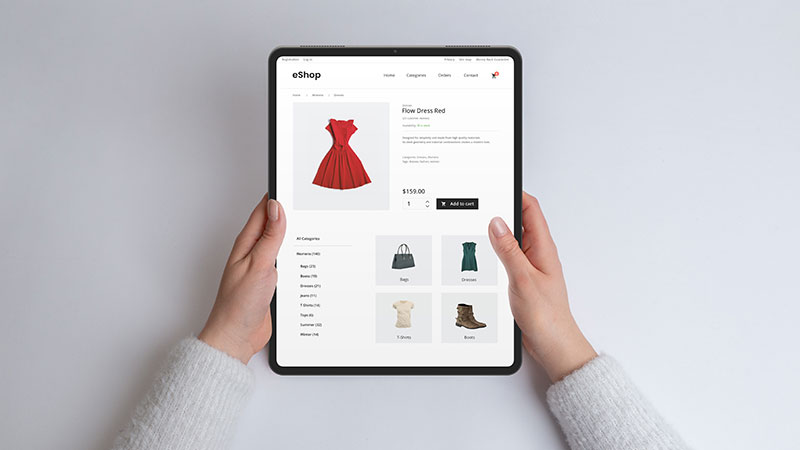 Mani che tengono un tablet moderno che mostra una pagina web di e-commerce. Concetto di shopping online con un'esperienza di navigazione fluida e comoda per acquisti alla moda e alla moda.